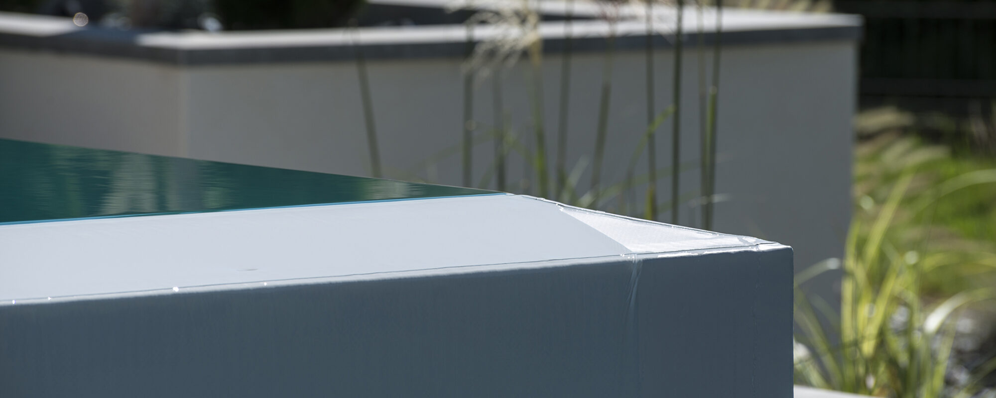 Piscine à débordement sur deux côtés, membrane armée gris clair