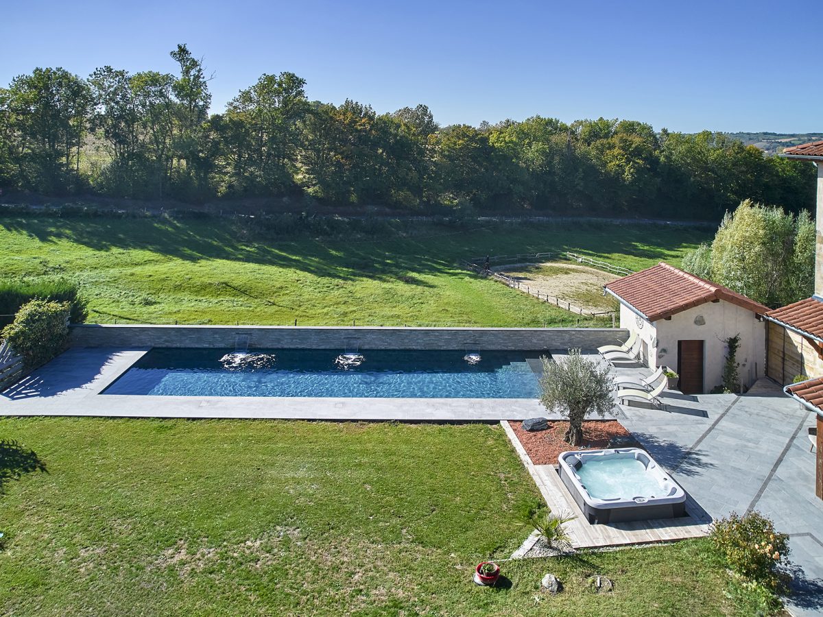 Couloir de Nage avec spa semi-encastré, margelles et plage en bois exotique
