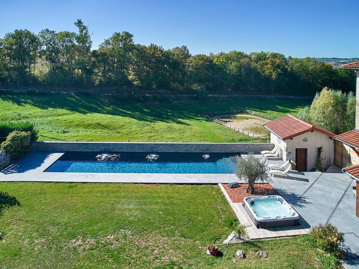 Couloir de Nage avec spa semi-encastré, margelles et plage en bois exotique