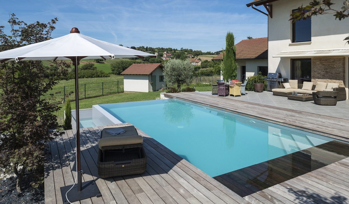 Piscine à débordement sur deux côtés, plage et margelles en bois