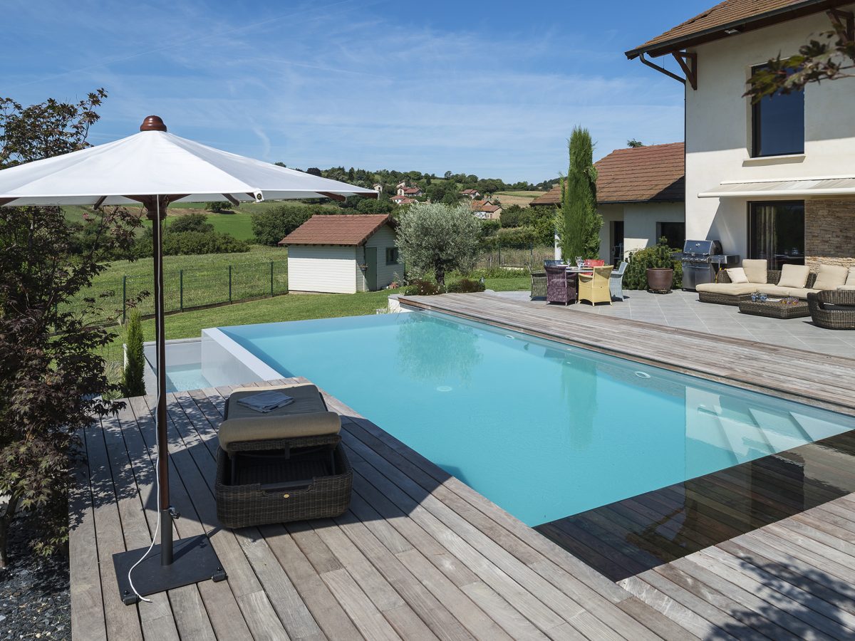 Piscine à débordement sur deux côtés, plage et margelles en bois