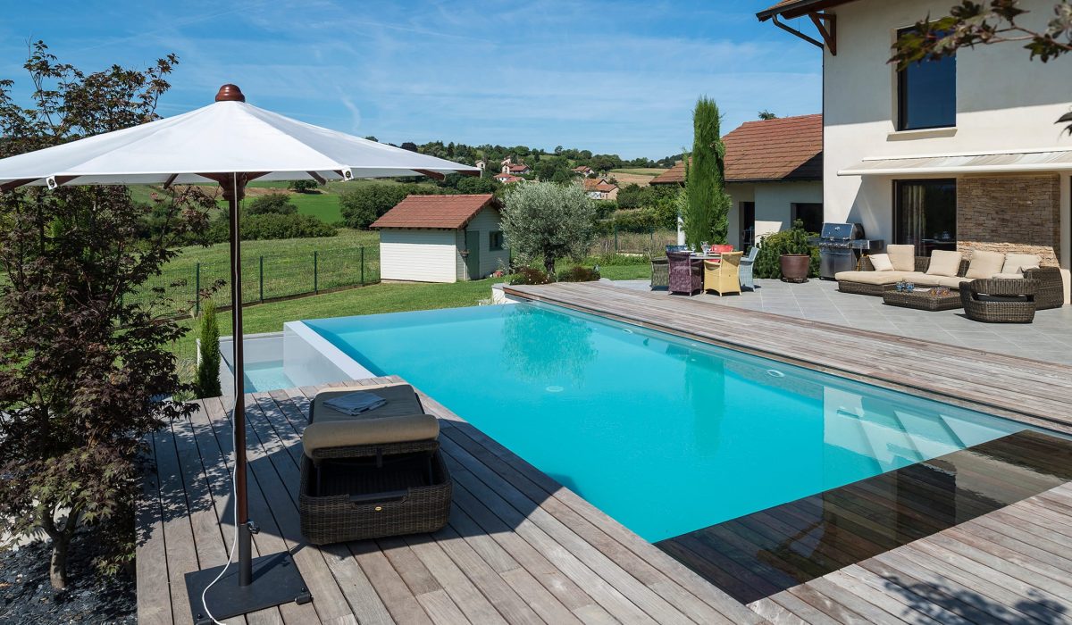 Piscine à débordement sur deux côtés, plage et margelles en bois