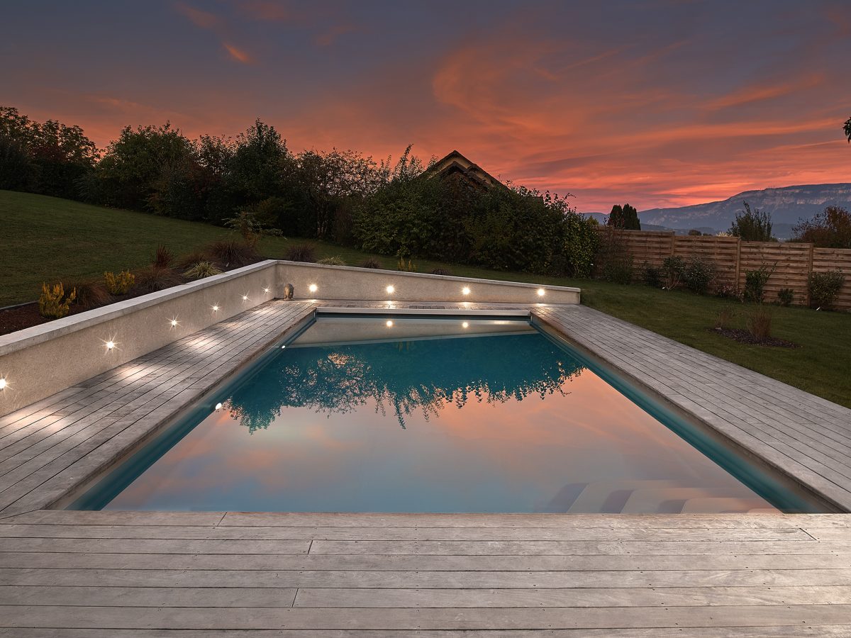 Piscine extérieure de 11 x 4.5 m avec spot leds et plage en bois exotique