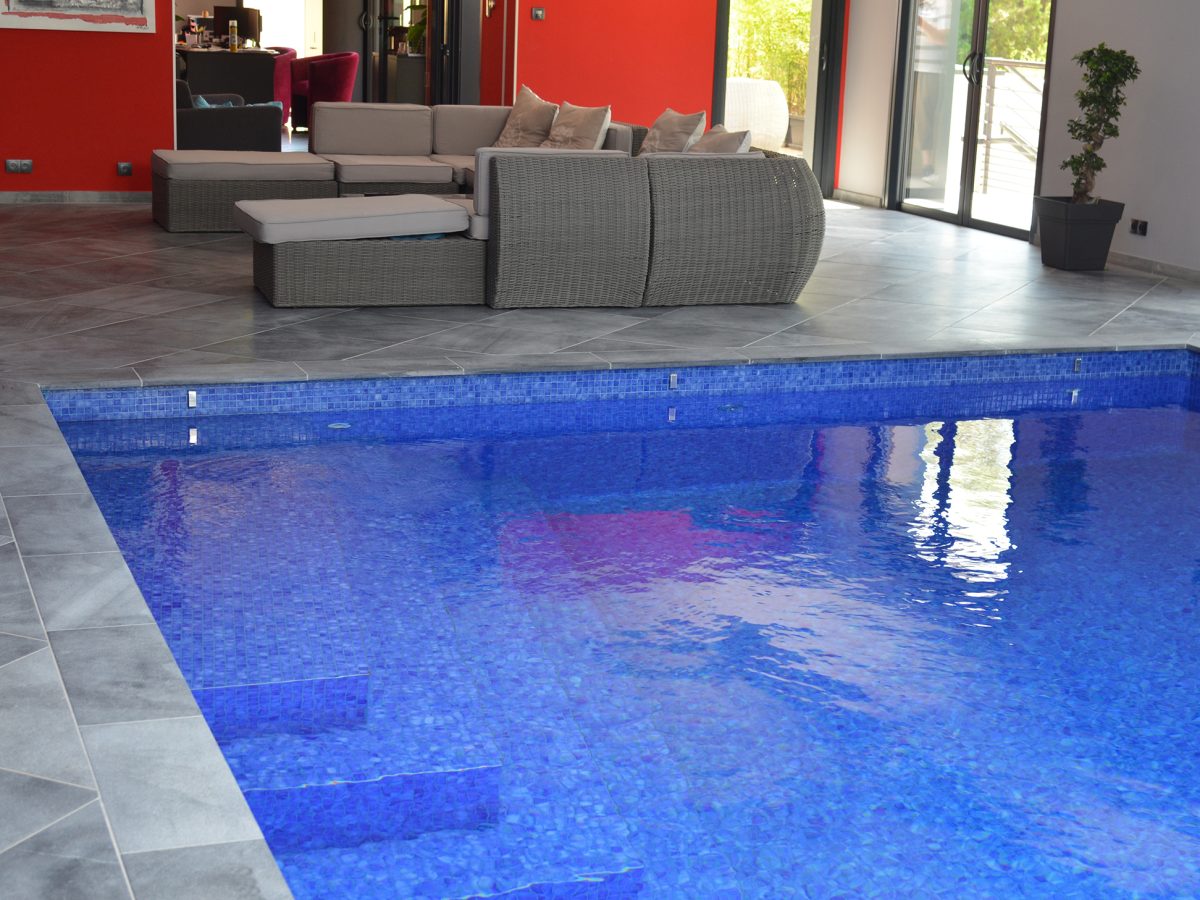 Piscine intérieure rectangulaire avec escalier d'angle et revêtement mosaïque