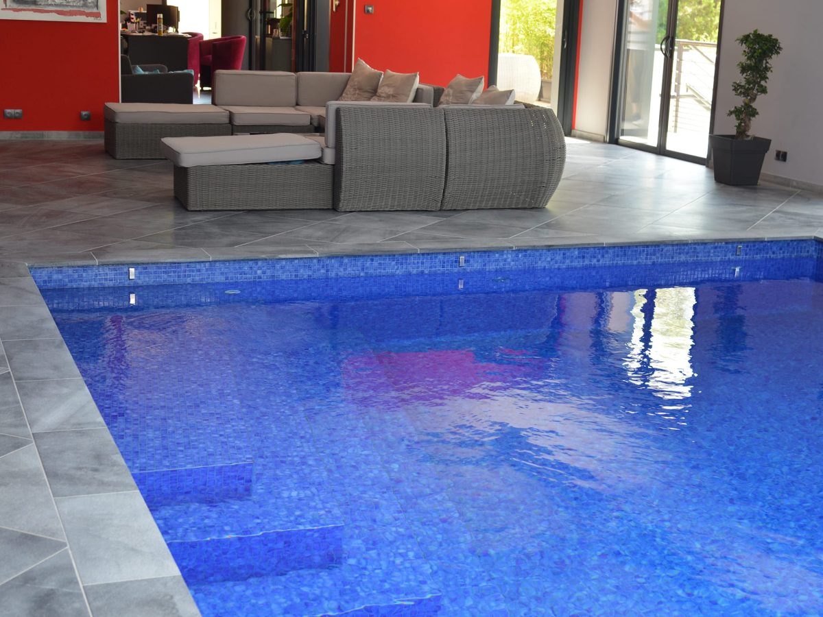 Piscine intérieure rectangulaire avec escalier d'angle et revêtement mosaïque