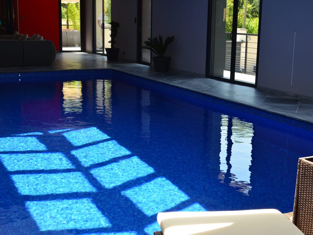 Piscine intérieure rectangulaire avec escalier d'angle et revêtement mosaïque